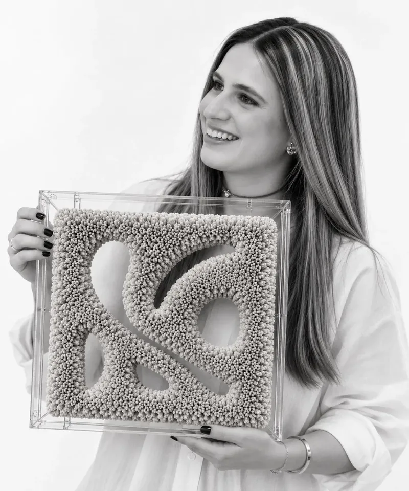 Debora Rabinowicz segurando uma obra Tressi